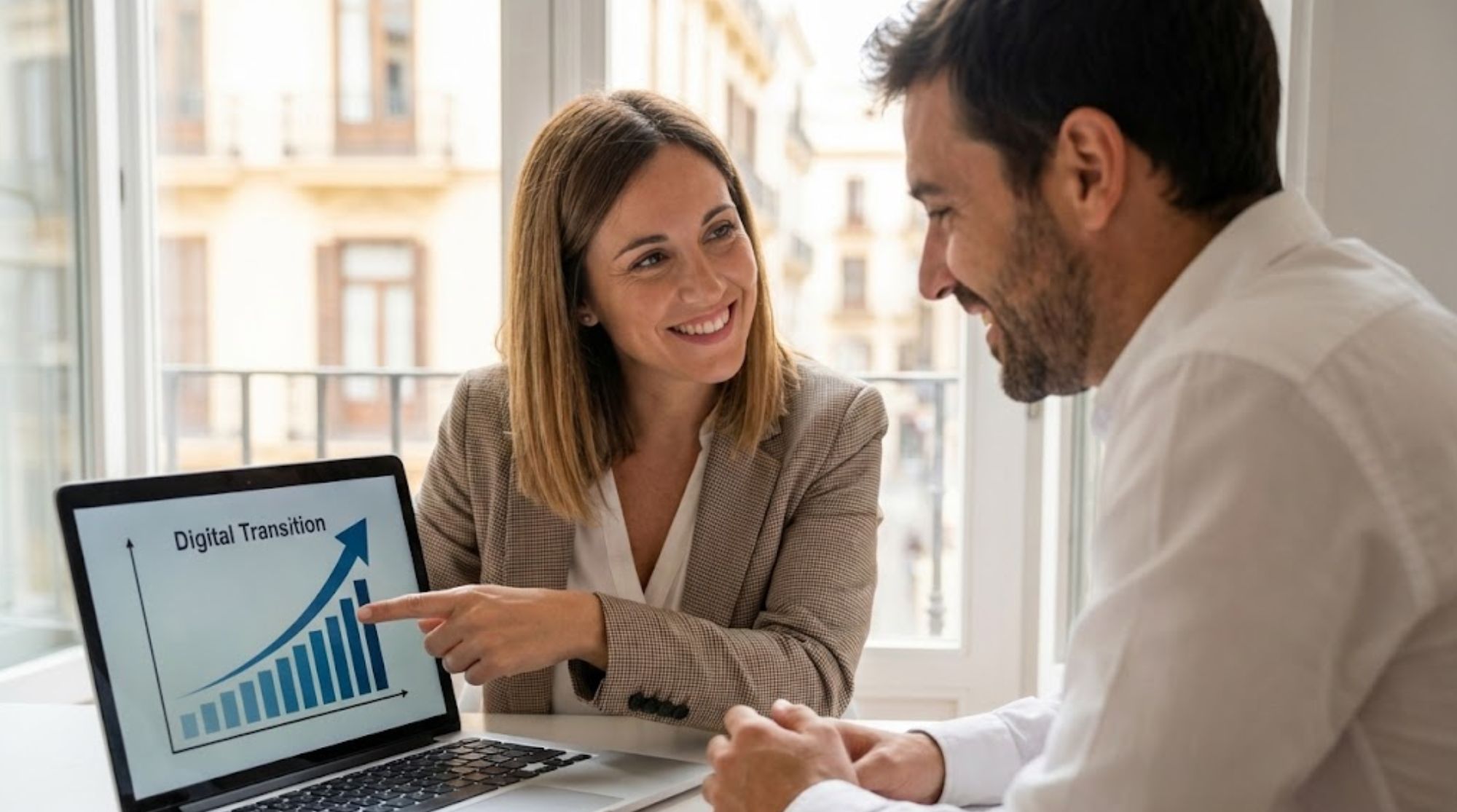 Profesionales discutiendo gráficos de transición digital en una laptop